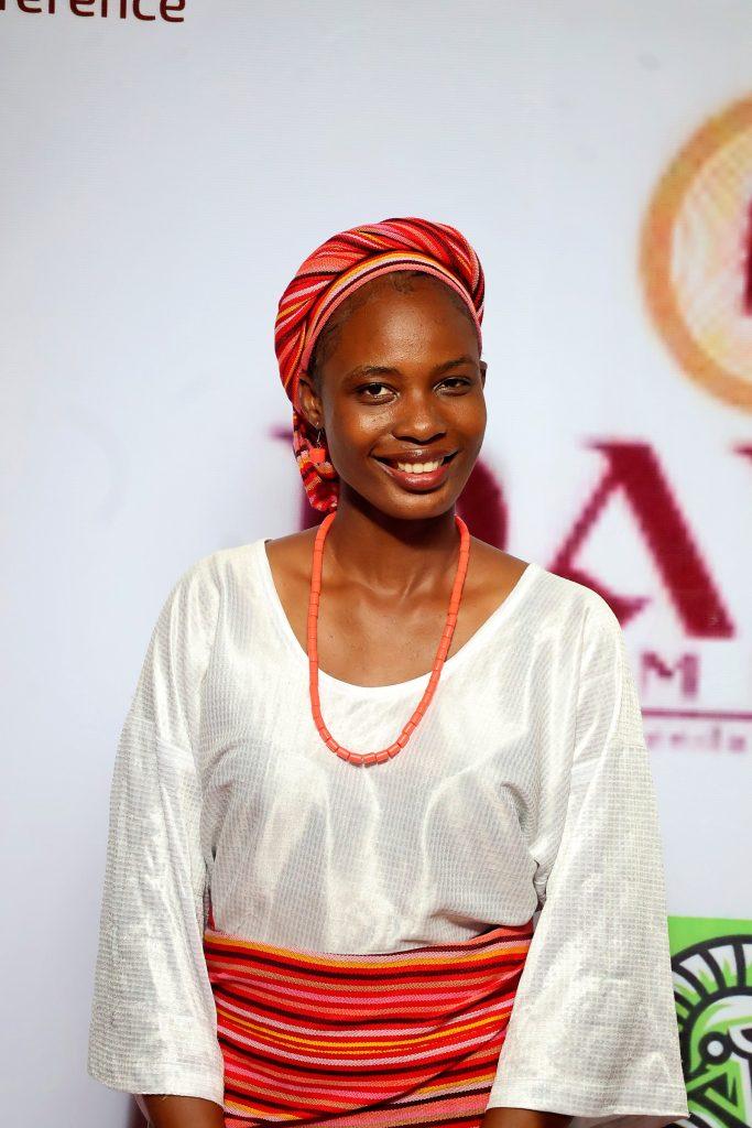 A guest in a red gèlè and coral beads at the 4th Annual Yorùbá Global Conference