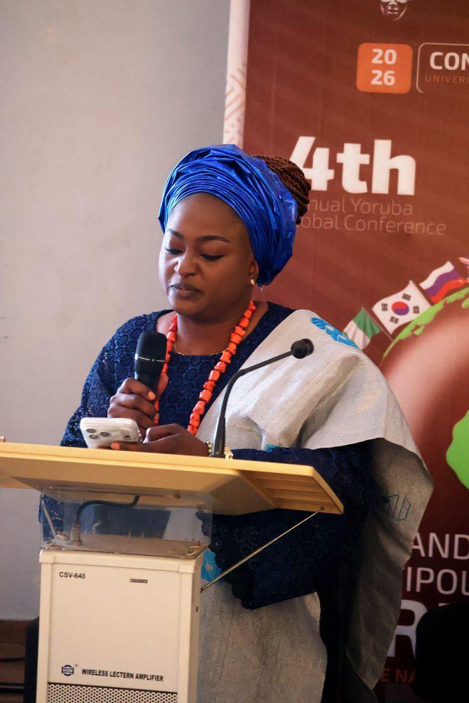 A delegate in a blue gèlè reads an address at the 4th Annual Yorùbá Global Conference